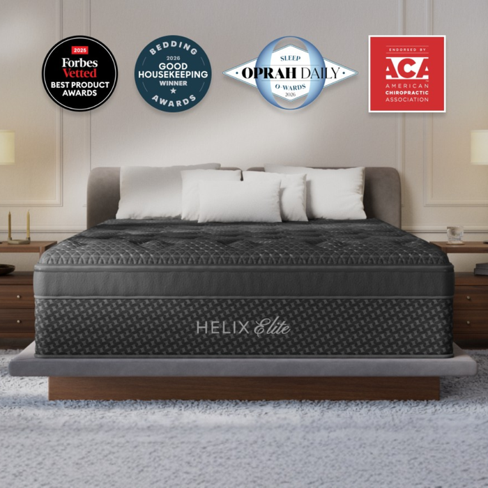 Helix Twilight Elite mattress with a black quilted top on an upholstered bed frame, with award and endorsement badges.