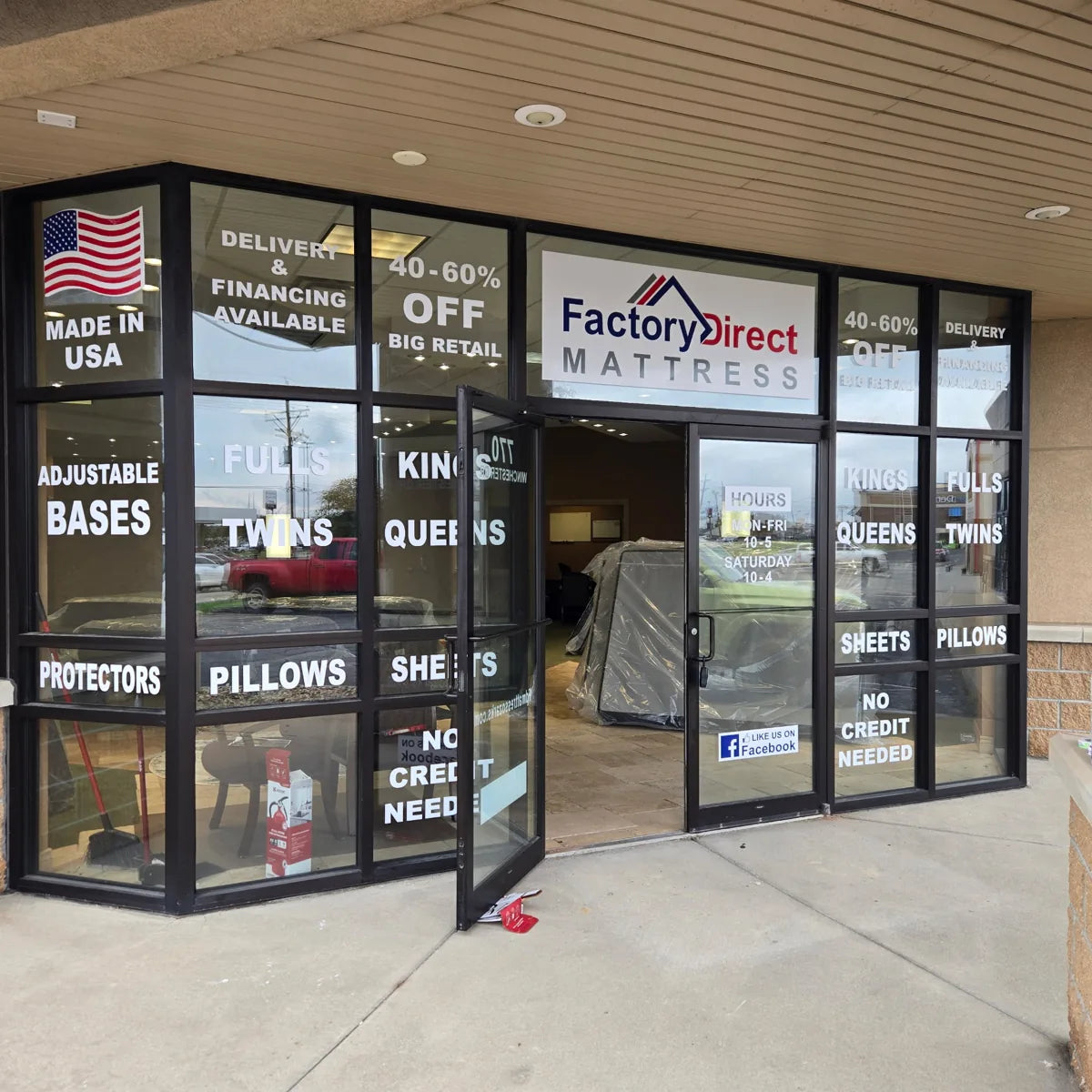 A closer look at the entrance while we prepared the store. Window hours shown are older.