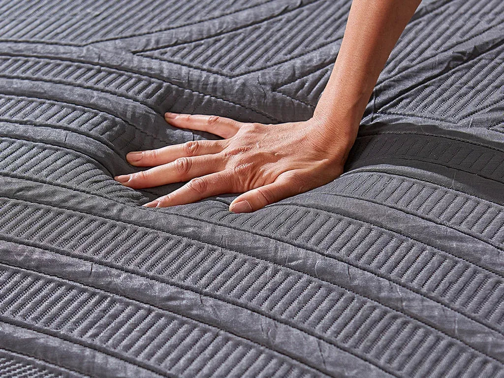 Hand pressing the surface of an MLILY PowerCool mattress